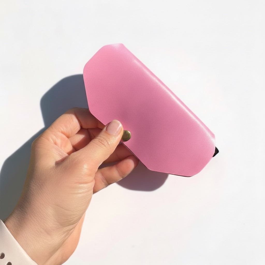 Azzohandmade pink slim Italian leather glasses case held in a hand, featuring a secure flap closure.