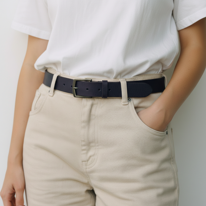 Person wearing a white shirt and beige pants with a black belt against a neutral background